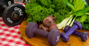 Dumbbells and leafy green vegetables on a table