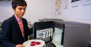 Dr Liezhou Zhong holding a plate with 3D printed food.