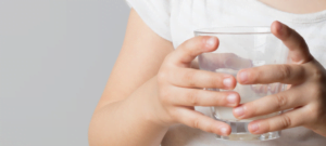 Child holding a glass of milk.
