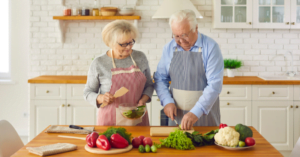 Older male and female preparing vegetables
