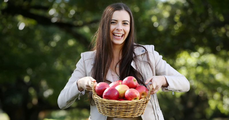 Dr Nicola Bondonno holding a basket of red apples